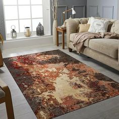 a living room filled with furniture and a large rug on the floor in front of a window