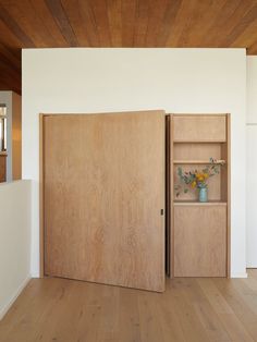 an empty room with wooden floors and white walls is seen in this image from the doorway