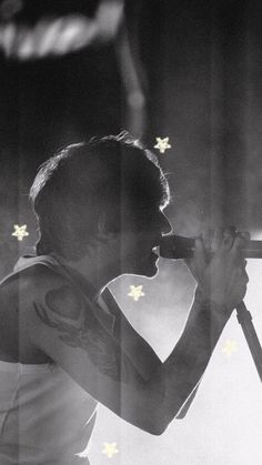 a black and white photo of a woman with stars on her arm holding a microphone