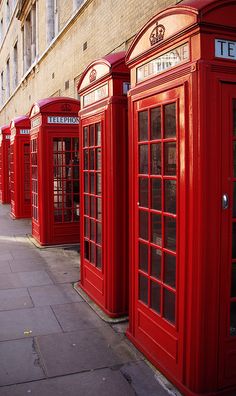 a row of red telephone booths sitting next to each other