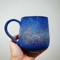 a hand holding a blue mug with stars on it