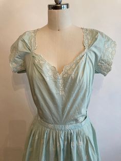 "Rare Clare Potter mint green embroidered floral cotton dress has scalloped sleeves, hem and neckline with a matching belt with a single covered button. Dress zips up in the back and is in excellent vintage condition. The bodice on the dress seems too have been made for someone with a long torso, so please mind the measurements listed below! Shoulders 17\" Chest 38-40\" Waist 28\" Hips 60\" Underarm seam to waist seam 9\" Length from top of shoulder to hem 45\" Vintage garments have been previou Elegant Cotton Dress With Scalloped Edges, Fitted Cotton Vintage Dress, Tea Length, Fitted Cotton Vintage Tea-length Dress, Vintage Green Dress With Floral Embroidery, Fitted Cotton Dress With Scalloped Edges, Fitted Tea-length Vintage Cotton Dress, Cotton Dresses With Scalloped Edges And Short Sleeves, 1950s Cotton Spring Dresses, 1950s Cotton Dresses For Spring