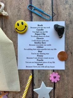 a rock and paper clip with a poem written on it next to some other items