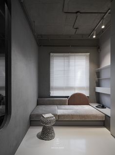 an empty room with a couch, table and shelves on the wall next to it