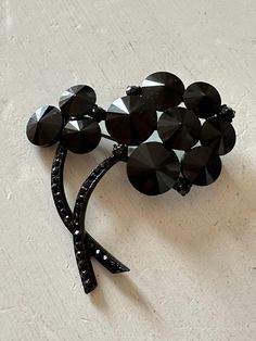 This listing is for a very unique and lovely vintage brooch by Weiss. It is 2 1/4" wide by 2 1/4" high with japanned metal, black rhinestone stems and flowers of rivoli stones. There is one tiny rhinestone missing from a stem (see Last Photo). The clasp is secure but note that the pin is bent - this does not affect closure. A unique and modern design! Albert Weiss designed exceptional jewelry in the United States from 1942-1971. This listing is for a very unique and lovely vintage brooch by Weis Antique Black Brooches For Evening, Antique Black Brooch For Evening, Antique Black Evening Brooch, Vintage Black Pins For Gift, Vintage Black Pins As Gift, Vintage Black Pins For Gifts, Vintage Black Pins As Gifts, Vintage Black Party Pins, Black Brooch Pins For Evening