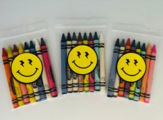 four different colored crayons with smiley faces on them