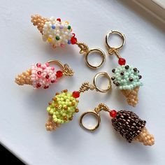 six different colored ice cream charms on a white surface