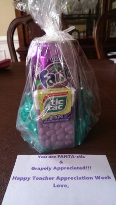 a plastic bag filled with candy sitting on top of a table next to a sign