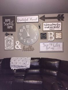 a living room with a couch, clock and other decorations on the wall above it