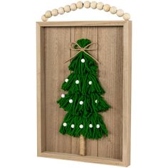 a wooden frame with a green christmas tree on the front and white balls around it