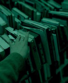 a person reaching for books in a library