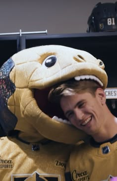 a man in a t - shirt is hugging a stuffed animal