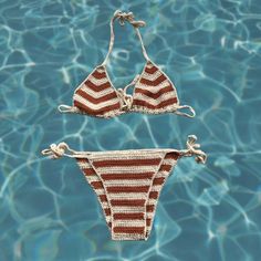 two bikinis are in the water with string attached to them, one is red and white