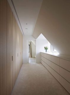 an attic bedroom with white walls and carpeted flooring, along with built - in closets