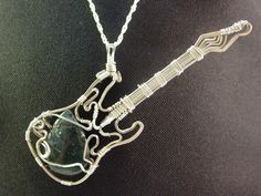 a silver necklace with a guitar pendant on it