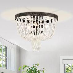 a chandelier hanging from the ceiling in a room with white walls and windows