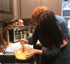 two people in the kitchen preparing food together