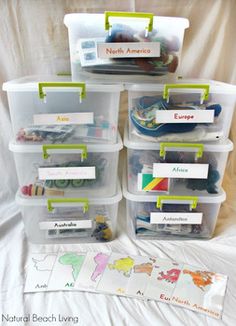 several plastic bins with labels on them are stacked next to each other in front of a white sheet