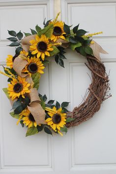 a wreath with sunflowers and burlocks hanging on the front door,