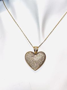 Stunning encrusted diamond heart pendant necklace. The 14K yellow gold twisted rope chain necklace (approx. .3mm) measures approx. 18" in length and closes with a spring ring clasp. The heart shaped pendant has over a hundred bezel set diamonds in white gold (over 1 carat!). The diamonds extend up the bale! The heart is outlined in roped 14k yellow gold border. The heart measures approx. 1" x 1 1/8" (including the bale). Each piece is marked 14K. 5.4 grams total weight Gold Diamond Accented Heart-shaped Necklace, Gold Heart-shaped Diamond Necklace With Accents, Gold Heart Diamond Necklace With Accents, Gold Jewelry With Pave Setting For Valentine's Day, Gold Diamond-cut Heart Pendant Necklace, Yellow Gold Heart Pendant Diamond Necklace, Gold Diamond Cut Heart Pendant Necklace, Gold Diamond Cut Necklace With Heart Pendant, Sparkling Yellow Gold Necklace For Anniversary