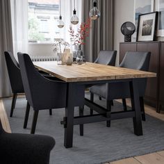 a dining room table and chairs in front of a window