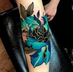 a woman's leg with a blue flower tattoo on her left arm and foot