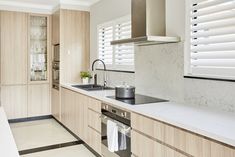 a kitchen with white counter tops and wooden cabinets, along with a stove top oven