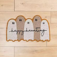 three ghost rugs with the words happy halloween written on them in front of a wood floor