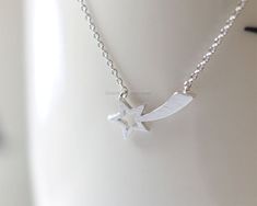 "This Silver Shooting Star necklace is perfect for celebrating life's little victories. - a stellar report card, job promotion, graduation, or a starring role in a school play. This adorable, whimsical necklace is so simple, it's perfect to wear every day either all alone or layered with other pieces. Silver shooting star Necklace is very simple and cute design handmade fashion jewelry. Necklace:\" Silver Shooting Star Necklace \" Material Chain: Silver Plated Or Sterling Silver Pendant: Silver Minimalist Star Charm Necklaces For Gift, Minimalist Star Charm Necklace Gift, Star-shaped Necklace For Mother's Day Gift, Mother's Day Star-shaped Necklace Gift, Mother's Day Star Shaped Necklace Gift, White Star Charm Necklaces For Gift, White Star Charm Necklace For Gift, White Star Charm Necklace Gift, Mother's Day Star Shaped Gift Necklace