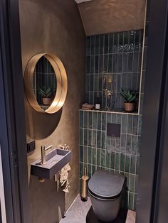 a bathroom with a toilet, sink and mirror on the wall next to each other