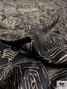 a black and gold fabric with an intricate design on it's center, as well as the back side