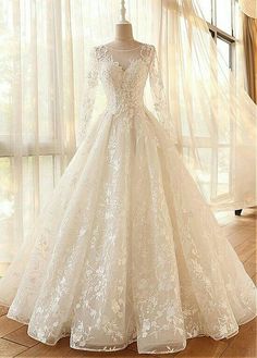 a white wedding dress on display in front of a window