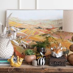 a table topped with vases and animal figurines on top of a wooden dresser