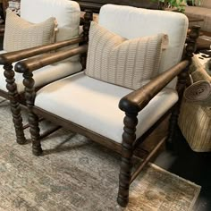 two wooden chairs sitting on top of a rug