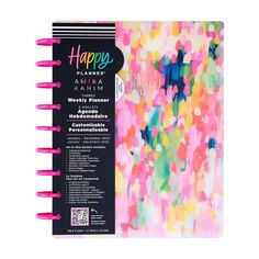 a happy planner book with pink and green paint splattered on it's cover