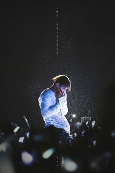 a man standing in the rain with his head down