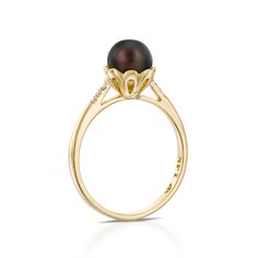 a black pearl and diamond ring in yellow gold