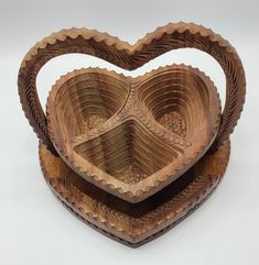 two wooden heart shaped bowls sitting on top of each other