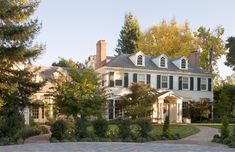 a large white house surrounded by trees and bushes