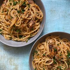 two bowls filled with pasta on top of a blue table