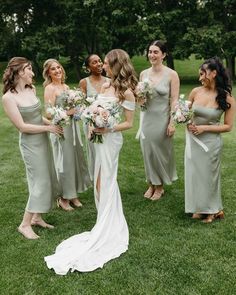 a group of women standing next to each other on top of a lush green field