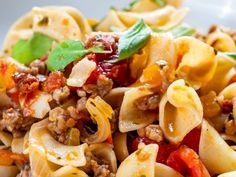 pasta with meat and vegetables in a white bowl