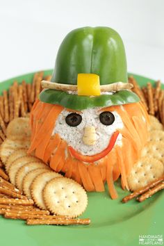 a green plate topped with crackers and a face