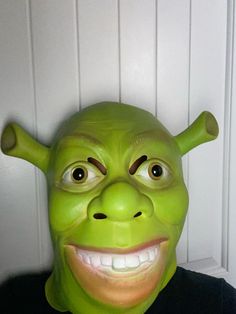 a man wearing a green troll mask with his eyes wide open