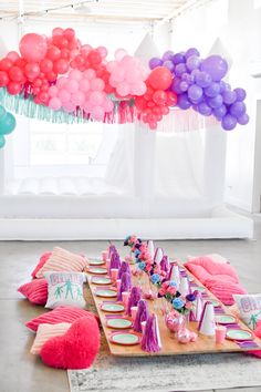 a party table with balloons and desserts on it