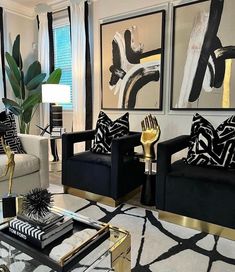 a living room filled with black and white furniture next to a large painting on the wall