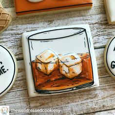 cookies decorated with icing and frosting on top of a wooden table next to each other