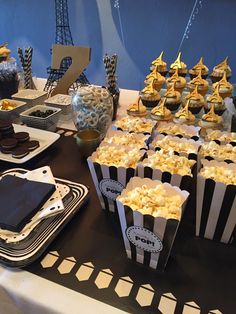 a table topped with black and white striped paper bags filled with cupcakes