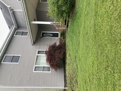 an aerial view of a house with a tree in the front yard and grass behind it