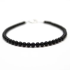 "Black Onyx beads are hand strung to form this classic single strand bracelet. The beads are tiny measuring about 3.0mm. This is a beautifully tiny, and delicate onyx bracelet. You could wear this alone or stack with other bracelets for a layering effect. I have hand strung these beads using a premium beading wire that has beautiful drape and it fastens with a sterling silver or gold filled lobster clasp. The bracelet is available in 6.0\" to 8.0\" lengths. Select your size at check out. Matchin Minimalist Onyx Round Bead Jewelry, Minimalist Onyx Bead Jewelry, Classic Onyx Beaded Bracelets With Adjustable Fit, Minimalist 8mm Onyx Bead Jewelry, Classic Black Round Beaded Jewelry, Minimalist Single Strand Beaded Bracelets With Round Beads, Classic Black Beaded Bracelets As Gift, Minimalist Onyx Beaded Bracelets With Round Beads, Minimalist Onyx Beaded Bracelet With Round Beads